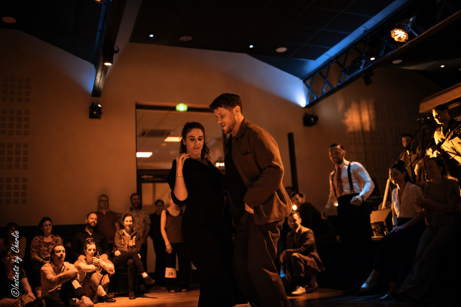 Couple de West Coast Swing dansant en connexion devant l'orchestre live